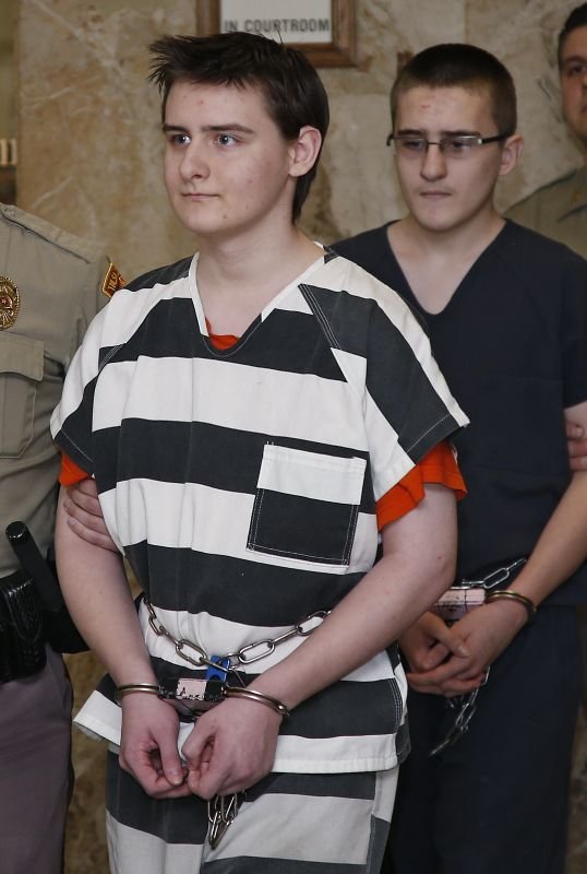 Robert Bever, left, and Michael Bever, right, are escorted into a courtroom for a hearing in Tulsa, Okla., Tuesday, Feb. 23, 2016. The two Oklahoma teenage brothers are charged with fatally stabbing their parents and three of their younger siblings. (AP Photo/Sue Ogrocki)
