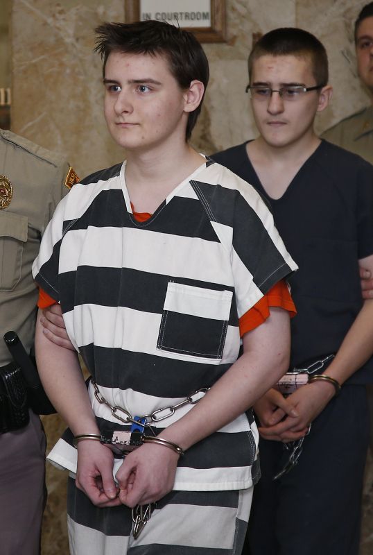 Robert Bever, left, and Michael Bever, right, are escorted into a courtroom for a hearing in Tulsa, Okla., Tuesday, Feb. 23, 2016. The two Oklahoma teenage brothers are charged with fatally stabbing their parents and three of their younger siblings. (AP Photo/Sue Ogrocki)